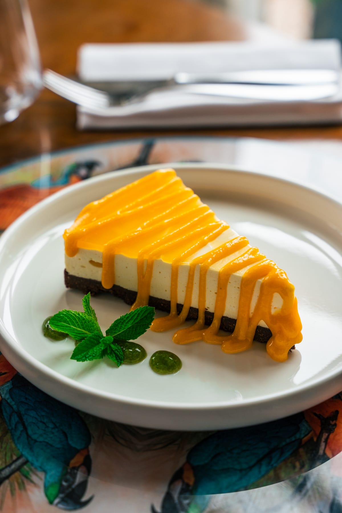 Fetta di cheesecake con salsa arancione e menta