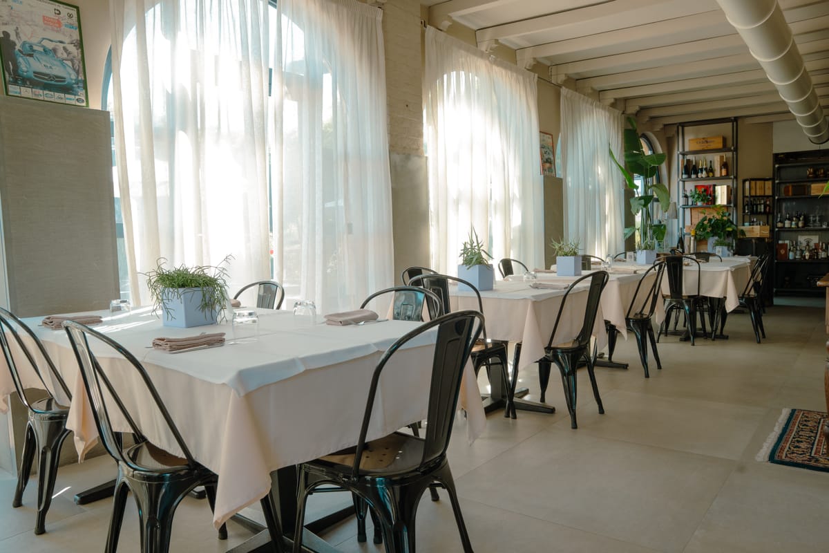Tavoli apparecchiati nella veranda luminosa